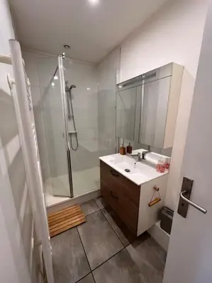 a bathroom with a shower and a sink and a mirror at Appartement Cosy à Narbonne in Narbonne
