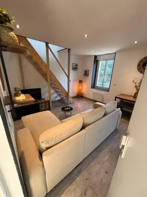 a living room with a couch and a staircase at Appartement Cosy à Narbonne in Narbonne