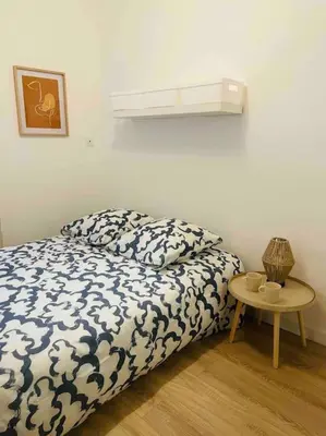 a bedroom with a bed and a small table at Le P'tit Stud' in Castres