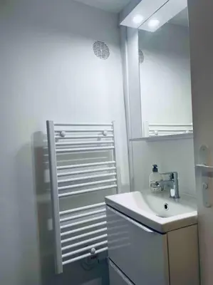 a white bathroom with a sink and a mirror at Le P'tit Stud' in Castres