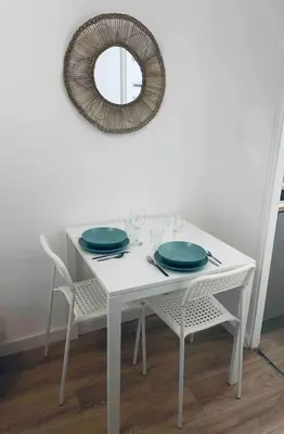 a white table with two blue plates and a mirror at Le P'tit Stud' in Castres
