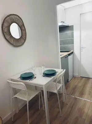 a white table with chairs and a mirror in a kitchen at Le P'tit Stud' in Castres