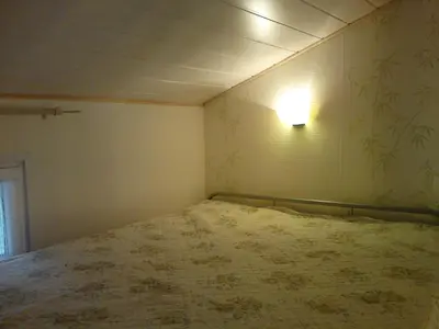 a room with a bed with a light on the wall at Le Cabanon in Lacrouzette