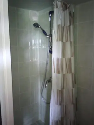 a shower with a shower curtain in a bathroom at Le Cabanon in Lacrouzette