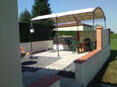 a patio with a table and chairs under a canopy at Le Cabanon in Lacrouzette