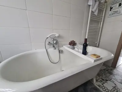 a white bath tub in a white tiled bathroom at Spacious Luxury 2 bed appartment in Carcassonne