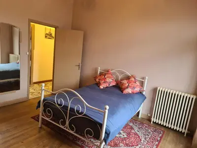 a bedroom with a blue bed with pillows on it at Spacious Luxury 2 bed appartment in Carcassonne