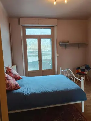 a bedroom with a bed with blue sheets and a window at Spacious Luxury 2 bed appartment in Carcassonne