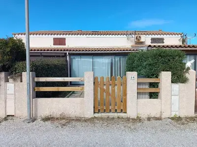 a wooden fence in front of a house at Pavillon 5 personnes in Port-la-Nouvelle
