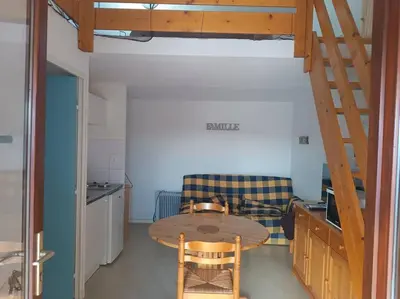 a living room with a table and a couch at Pavillon 5 personnes in Port-la-Nouvelle