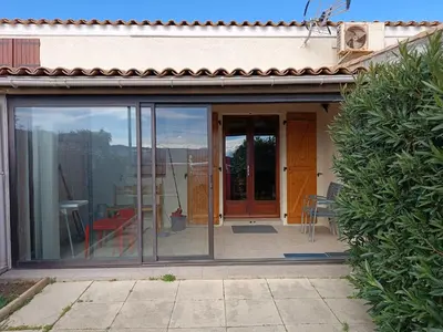 a sliding glass door of a house with a patio at Pavillon 5 personnes in Port-la-Nouvelle