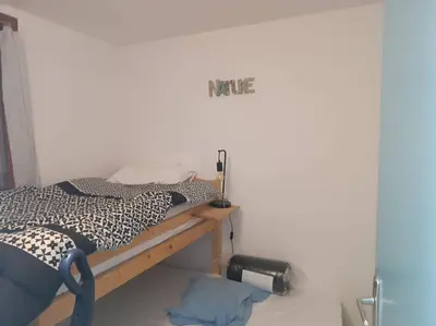 a bed in a room with a sign on the wall at Pavillon 5 personnes in Port-la-Nouvelle
