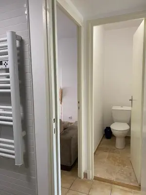 a kitchen and living room with a couch and a sink at T2 cosy avec espace extérieur in Lézignan-Corbières