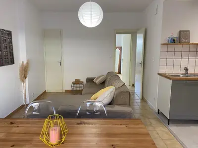 a living room with a couch and a table at T2 cosy avec espace extérieur in Lézignan-Corbières