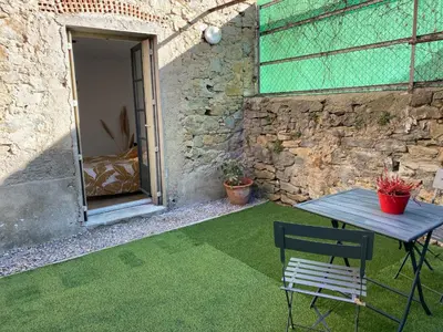 a living room with a couch and a kitchen at T2 cosy avec espace extérieur in Lézignan-Corbières