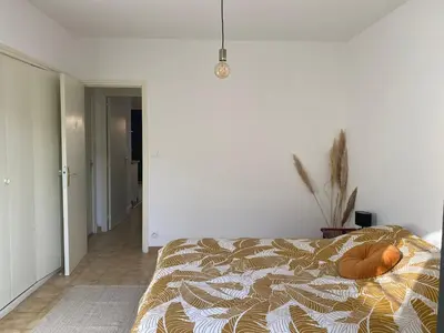 a kitchen and living room with a table and a couch at T2 cosy avec espace extérieur in Lézignan-Corbières