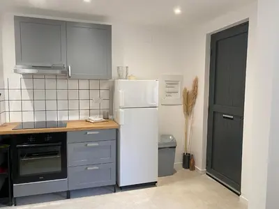 a bathroom with a toilet and a couch at T2 cosy avec espace extérieur in Lézignan-Corbières