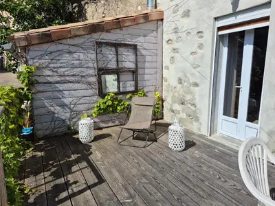 a wooden deck with two chairs and a building at grande terrasse avec vue entre méditerranée et pays cathare in Cailla