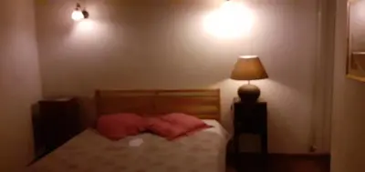 a bedroom with a bed with two pillows and a lamp at grande terrasse avec vue entre méditerranée et pays cathare in Cailla