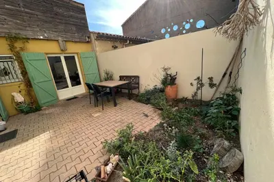 an outdoor patio with a table and chairs at La Lucquette - House near the Grands Buffets in Narbonne