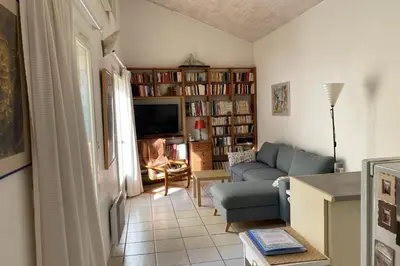 a living room with a blue couch and a tv at La Lucquette - House near the Grands Buffets in Narbonne