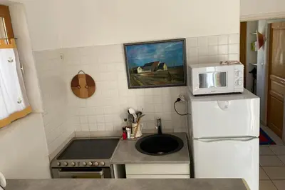 a kitchen with a microwave on top of a refrigerator at La Lucquette - House near the Grands Buffets in Narbonne