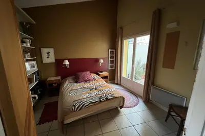 a bedroom with a bed and a large window at La Lucquette - House near the Grands Buffets in Narbonne