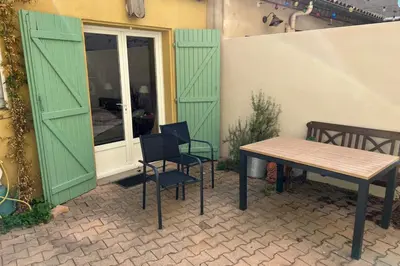 a patio with a table and chairs next to a building at La Lucquette - House near the Grands Buffets in Narbonne