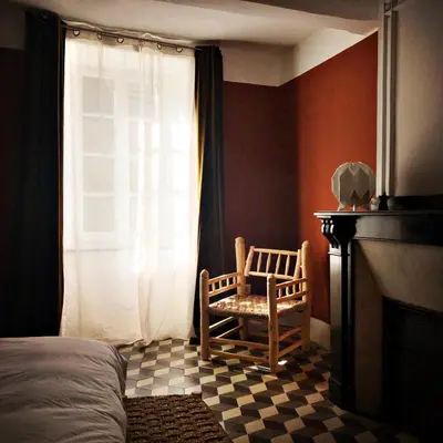 a bedroom with a chair next to a fireplace at B&B Vigne Vierge in Aigne