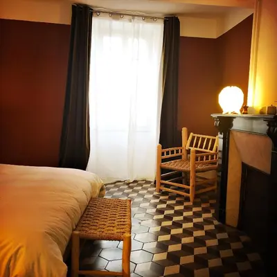 a bedroom with a bed and a fireplace and a window at B&B Vigne Vierge in Aigne