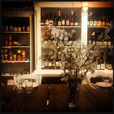 a table with a vase of flowers and wine bottles at B&B Vigne Vierge in Aigne