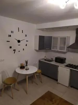 a kitchen with a table and a clock on the wall at Studio proche du centre-ville in Carcassonne