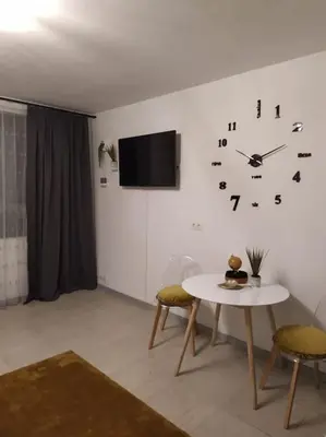 a room with a table and a clock on the wall at Studio proche du centre-ville in Carcassonne