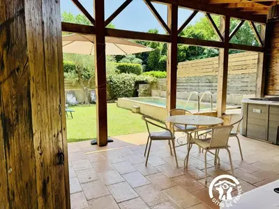 a patio with a table and chairs and an umbrella at Gîte de caractère La Grange Saint Papoul in Saint-Papoul