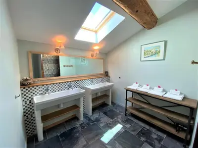 a bathroom with two sinks and a large mirror at Gîte de caractère La Grange Saint Papoul in Saint-Papoul