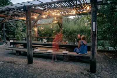 a couple sitting on a bench under a pergola at Fount Estremiero - Chambres & tables d'hôtes in Castans