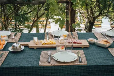 a table with a green table cloth with food on it at Fount Estremiero - Chambres & tables d'hôtes in Castans