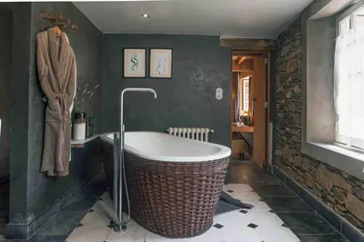 a bathroom with a large tub and green walls at Fount Estremiero - Chambres & tables d'hôtes in Castans