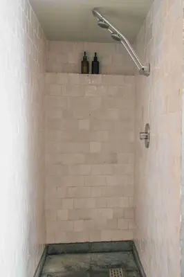 a bathroom with a shower with white tiled walls at Fount Estremiero - Chambres & tables d'hôtes in Castans