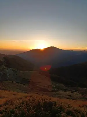 a sunset over a mountain range with the sun setting at Le Castel d'olmes in Laroque-dʼOlmes