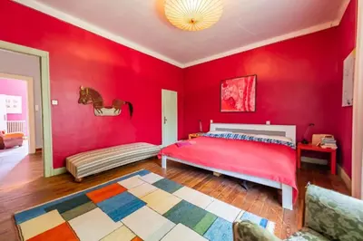 a bedroom with red walls and a large bed at DEMEURE BERGAMOTE de FONTIERS in Fontiers-Cabardès