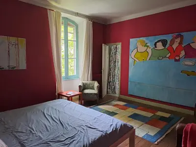 a bedroom with a bed and a painting on the wall at DEMEURE BERGAMOTE de FONTIERS in Fontiers-Cabardès