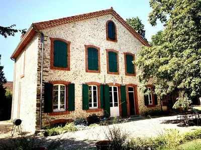 a large brick house with green shutters at Sous le Tilleul de la Condomine in Payrin-Augmontel