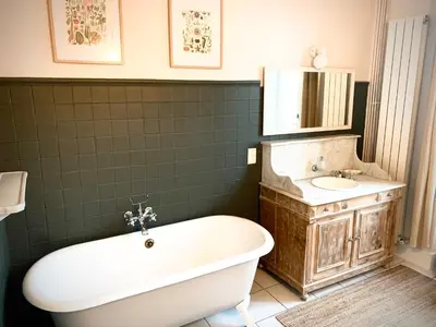 a bathroom with a tub and a sink at Sous le Tilleul de la Condomine in Payrin-Augmontel