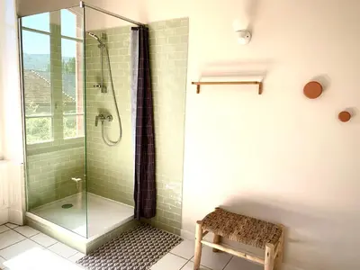 a bathroom with a glass shower with a bench at Sous le Tilleul de la Condomine in Payrin-Augmontel