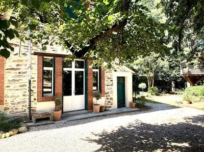 a brick house with a white door and some plants at Sous le Tilleul de la Condomine in Payrin-Augmontel