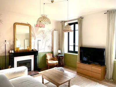 a living room with a couch and a tv and a mirror at Sous le Tilleul de la Condomine in Payrin-Augmontel