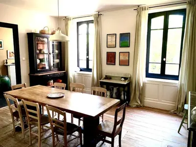a dining room with a wooden table and chairs at Sous le Tilleul de la Condomine in Payrin-Augmontel