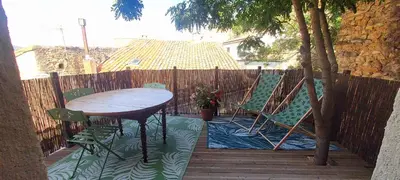 a patio with a table and chairs and a fence at jolie maison avec terrasse in Cessenon
