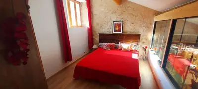 a bedroom with a red bed with a red blanket at jolie maison avec terrasse in Cessenon